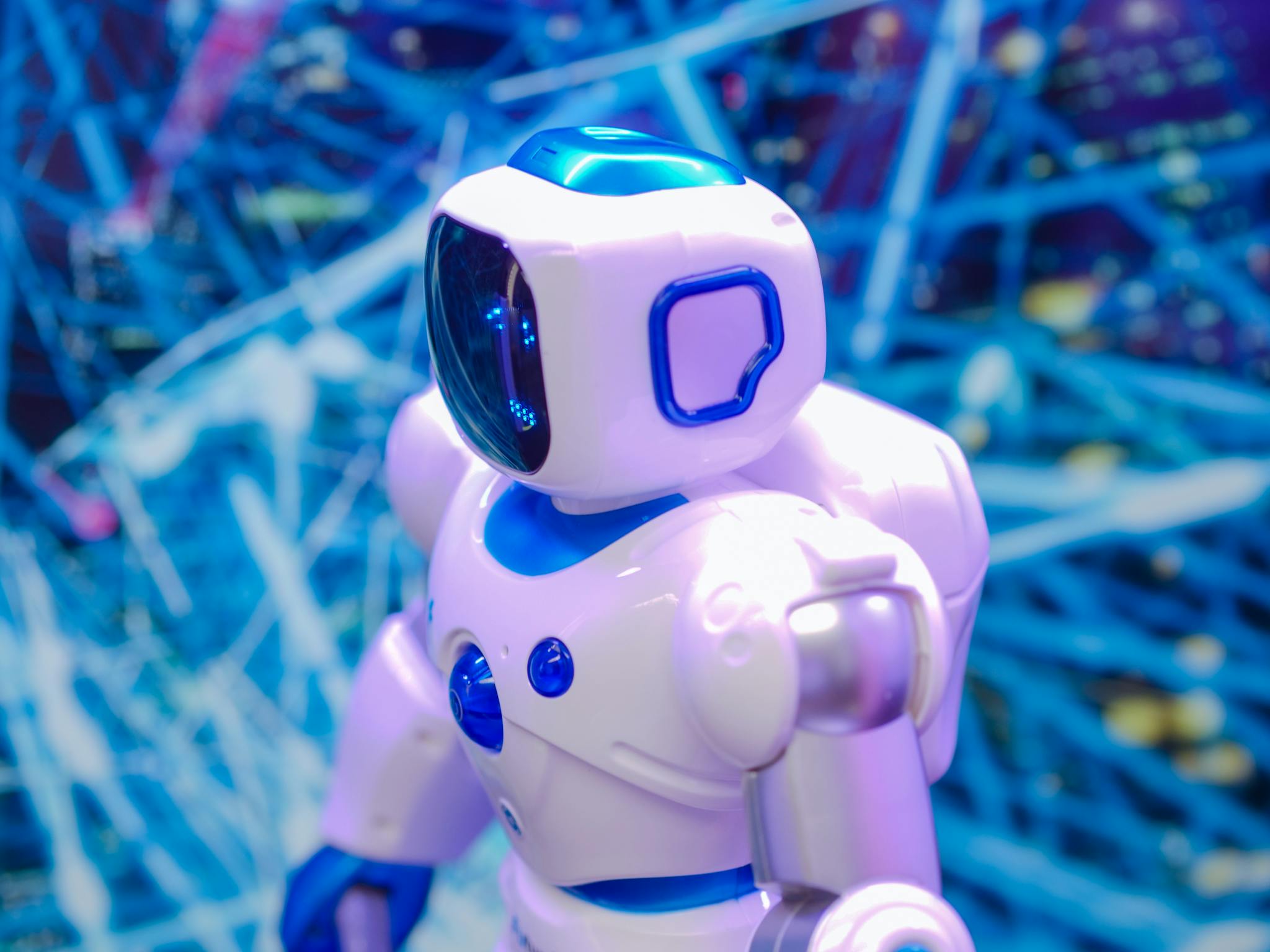 Close-up of a white and blue robot against a dynamic, futuristic tech backdrop.