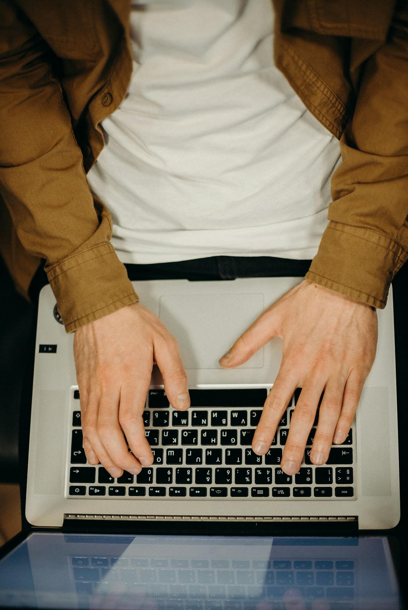 Top view of hands typing on a laptop, showcasing technology and remote work.